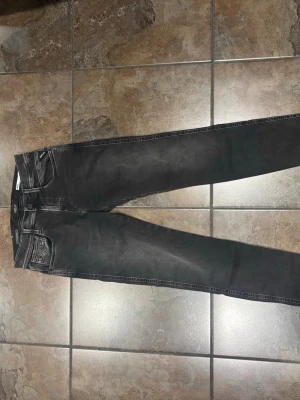 Svarta jeans med slitningar - Snygga svarta skinny jeans med lätt slitna detaljer och klassisk femficksmodell. Jeansen har en bra passform och är tillverkade i stretchigt denimtyg för extra komfort. Perfekta till en avslappnad streetstyle-look.