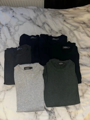 6-pack basic t-shirts i olika färger - Säljer ett 6-pack basic t-shirts från Dressmann i färgerna svart, mörkblå, mörkgrå, grå, mörkgrön och marinblå. Alla har rund hals och klassisk passform. Perfekta till vardags och enkla att matcha med allt. Materialet är mjuk bomull.