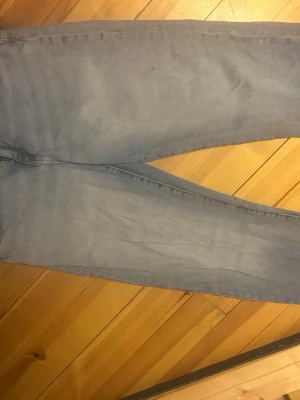 Ljusblåa  jeans - Säljer ett par ljusblåa  jeans med smal passform och klassisk femficksdesign. Jeansen har en enkel look utan slitningar eller dekorationer och är tillverkade i ett mjukt denimtyg  