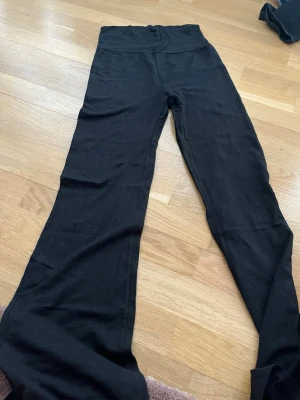 Svarta leggings från Kappahl - Säljer ett par svarta leggings från Kappahl i storlek 170. De viks vid höfterna och är tillverkade i ett mjukt och stretchigt material som sitter skönt på kroppen. Perfekta att matcha med oversized tröjor eller hoodies.