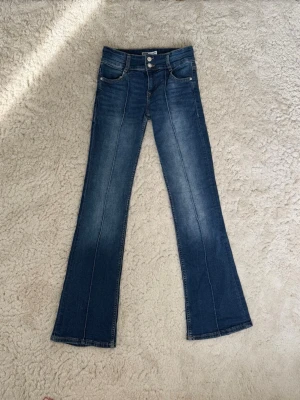 Blåa bootcut jeans från Bershka - Säljer dessa snygga jeans från Bershka, i storlek 36. Jeansen är bootcut, lågmidjade och blåa i färgen.   De är änvända 2-3 gånger, därav i väldigt bra skick.💕