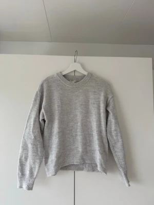 Ljusgrå stickad tröja från Gina Tricot - Säljer en snygg ljusgrå stickad tröja från Gina Tricot, i storlek 158/164. Tröjan har en avslappnad passform.  Den är använd och har få tecken på användning, men i väldigt fint skick.💕