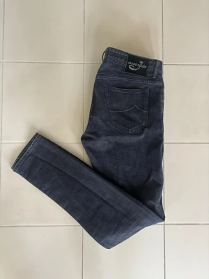 Jeans Jacob Cohen - Extremt snygga jeans från Jacob Cohen i svart färg. Byxorna är i toppskick och otroligt fräscha vilket höjer byxorna väsentligt. Passformen är grym, materialet är klass och badgen är som ny. Ett måste till garderoben! Längd - 114 cm och bredd - 49 cm. Tveka inte på att ställa eventuella frågor!