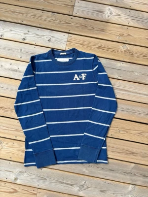 Vintage 2000s Abercrombie & Fitch tröja  - Säljer denna otroligt feta Vintage 2000s Abercrombie & Fitch tröja i modellen Muscle, inga defekter! Storlek L. Kontrollera måtten innan ni köper! Hör av er vid frågor eller minsta fundering 🙌  Se mått nedan:  Längd: 70,5 cm  Bred: 50 cm  Ärm: 68 cm