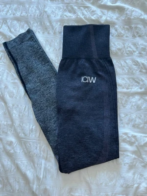 Mörkgrå seamless leggings från ICIW - Snygga mörkgrå seamless leggings från ICIW med hög midja och ribbad linning. Materialet är stretchigt och följsamt, perfekt för träning. Diskret logga på höften och snygga detaljer längs benen.