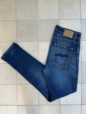 Blå jeans från Nudie Jeans - Säljer ett par sjukt feta jeans från Nudie Jeans  som är i ett mycket fint skick! Modellen är Lean Dean!                                        ———————————————————————————📐| Storlek: 31-32 (måtten finns på bild 6 & 7)                                            👖| Märke: Nudie jeans                                         🔎| Skick: Fint skick!                                               💵| Ny Pris: 1599kr                                                   ✍🏻| Skriv om du har några frågor