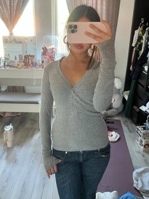 Grå långärmad tröja - Säljer en grå ribbad långärmad tröja med v-ringning. Tröjan är från Bikbok i storlek XS💕