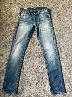 Jack and Jones jeans tvättad look - Säljer ett par blåa jeans från Jack and Jones med klassisk femficksmodell och snygg tvättad look. Skick 9/10 nypris - 899kr säljs - 599kr vid minsta fundering bara att höra av sig.