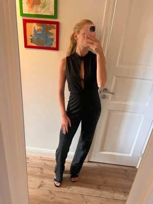 Svart ärmlös jumpsuit med cut-outs - Snygg svart jumpsuit, älskaaar men den är för lång för mig. Jag är 165 och har även klackar på typ 5 cm här. Köpte för 500 säljer för 150. 