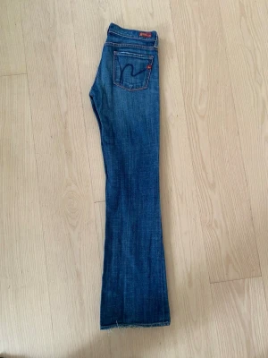 Citezen of humanity jeans från 2003. - Säljer ett par klassiska blå bootcut jeans med låg midja.  Fint använt skick. En viss slitning ska det vara men längst ner på benet är de lite söndertrampat (se sista bild).