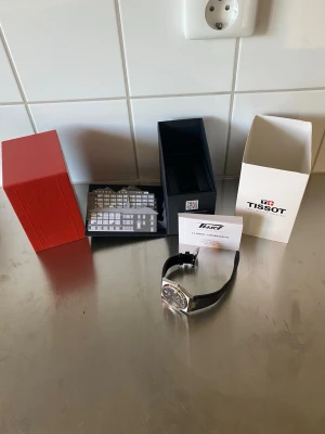 Tissot prx Powermatic 80 automatisk svart urtavla  - Säljer nu min mycket fina Tissot PRX Powermatic 80 i den populära 40 mm-versionen med svart urtavla och otroligt skönt läderarmband från Tissot.  Klockan fungerar utmärkt med det pålitliga powermatic 80 urverket. Den är i väldigt gott använt skick och ser ut som ny med normala mindre bruksspår som inte går att undvika vid vardagligt bruk. Klockan levereras med alla tillbehör som bilderna visar. Jag har gott om referenser hör av er vid frågor eller funderingar. 