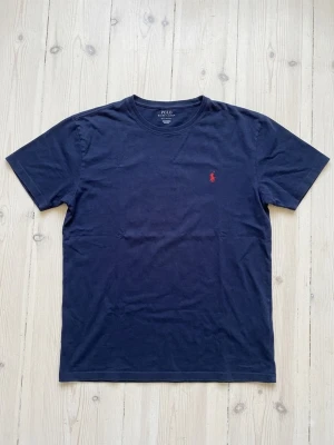 Ralph Lauren T-shirt  - Säljer denna snygga marinblå Ralph Lauren T-shirt. Den i perfekt skick och inga defekter. Vid funderingar skriv gärna. 