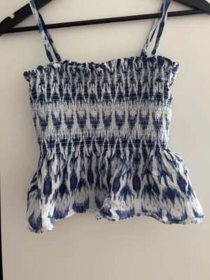 Blåvit smockad linnetopp Gina Tricot - Populär Topp från Gina som inte säljs längre. Går att ha både som topp och kjol då man kan ta av banden. Använd några gånger. Kom gärna med prisförslag!💗
