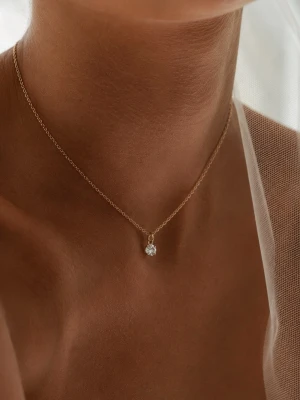Guldhalsband med liten sten - Ett tunt och elegant halsband i guld med en liten, rund sten som hänge. Kedjan är finlänkad och smycket har en minimalistisk och stilren design som passar perfekt till alla tillfällen.