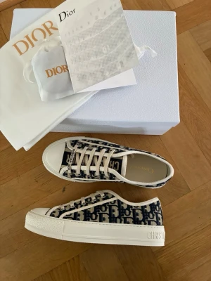 Dior sneakers  - Säljer mina Walk’n dior sneakers i storlek 37. Perfekta sommarskor! Skicket är som ny och tillbehören på bilderna medföljer inklusive vita skosnören. Kvitto finns. 