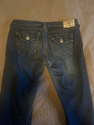 True religion jeans  - Snygga True religion jeans som är i fint skick! Är uppsydda i längden och passar bäst för någon runt 160cm, beroende på hur man vill att de ska sitta. Jag är 163cm och de passar bra. Mått kan skickas vid intresse! Pris kan diskuteras vid snabb och smidig affär. Storleken är W29 vilket är ungefär storleken M/L.  