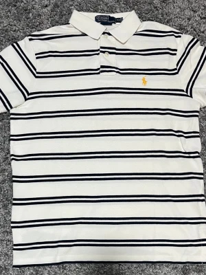 Polo Ralph Lauren piké - Vit polo ralph lauren piké i jätte fint skick. Använd väldigt fåtal gånger. Säljer eftersom jag vuxit ur den. Inga defekter alls. Hör av er vid frågor eller funderingar😊