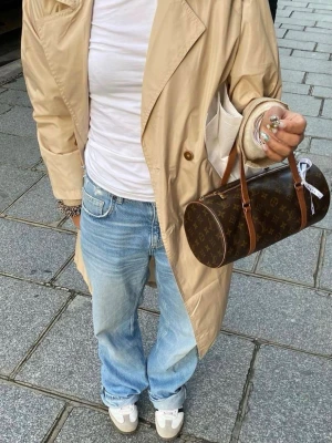 Louis Vuitton Papillon Monogram väska - Säljer en klassisk Louis Vuitton Papillon handväska i brunt monogramcanvas med cylinderform och bruna läderdetaljer. Väskan har två handtag och dragkedja upptill. Perfekt för dig som gillar tidlös och ikonisk design.