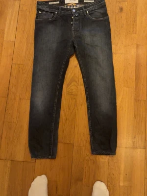 Jacob Cohen mörkblå slim fit jeans - Säljer ett par mörkblå slim fit jeans med klassisk femficksdesign och knappgylf. Jeansen har en lätt tvättad look och raka ben. Perfekta för dig som gillar en enkel och stilren stil. 