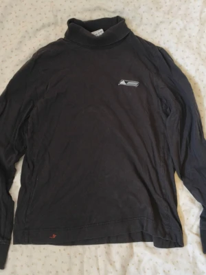 Adidas svart polotröja  - Säljer en svart långärmad polotröja från Adidas med liten broderad logga på bröstet. Tröjan har en klassisk polokrage och är tillverkad i mjukt material, perfekt för lager på lager. Enkel och stilren design som passar till det mesta.