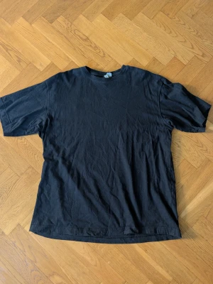 Svart basic t-shirt i bomull - Enkel svart t-shirt i mjuk bomull med rund hals och korta ärmar. Perfekt till jeans eller shorts för en clean och avslappnad stil. Klassisk passform och utan tryck eller mönster.