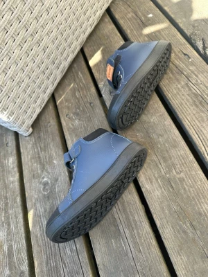 Blå sneakers från Kavat med kardborre - Snygga blå sneakers från Kavat med svarta detaljer, kardborreband och svarta skosnören. Skorna har en slitstark gummisula och är tillverkade i tåligt material med förstärkt tå och häl. Perfekta för dig som vill ha både stil och funktion.