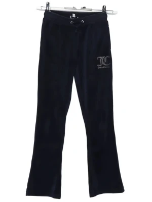 Svarta velourbyxor Juicy Couture - Mysiga svarta mjukisbyxor från Juicy Couture i mjuk velour. Byxorna har dragsko i midjan och ett glittrigt Juicy Couture-logotryck på ena benet. Perfekta för chill dagar eller när du vill ha en avslappnad look💗