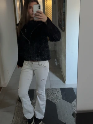 Vita bootcut jeans med slitningar - Säljer ett par vita bootcut jeans 