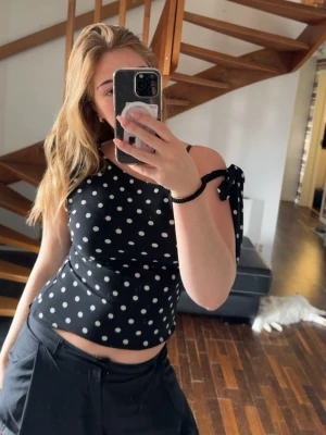 Prickig topp - Snygg svart oneshoulder topp med vita prickar och en knyt-detalj på axeln 💝