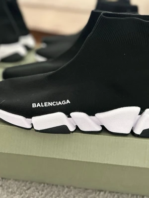 B skor 2.0 - Svarta sock sneakers från Bmed vit chunky sula och stretchigt stickat material. Loggan är tryckt i vitt på sidan. Skorna har en strumpliknande passform och modern design som sticker ut.
