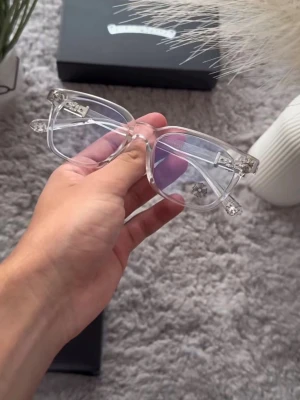Transparenta fyrkantiga solglasögon - Säljer ett par trendiga solglasögon med transparent båge och fyrkantig form. Glasögonen har en stilren och modern look som passar perfekt till alla outfits. Lätta och bekväma att bära hela dagen.