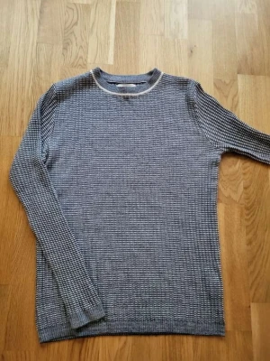 Blåvit stickad tröja - Säljer en blåvit stickad tröja från River Island i storlek M. Riktigt arhcive. Tröjan är i väldigt bra skick. Stretchigt och skönt material.
