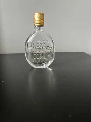 Diesel parfym 50 ml - Säljer en parfym från Diesel på 50 ml. Flaskan är rund och genomskinlig med präglad text och har ett guldfärgat lock. En stilren och modern design som passar perfekt i badrumshyllan.