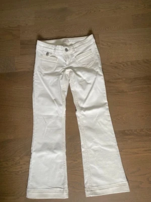 Vita low waist jeans från Nelly - Helt oanvända jeans i storlek 34 short. De är dock avsydda och passar mig som är 156cm. Köpta för 599kr.  Endast testade! Skriv vid frågor eller funderingar🥰pris kan diskuteras!