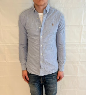 Polo Ralph Lauren Slim Fit Shirt Light Blue - Ljusblå skjorta i slim fit av 100% bomull. Begagnad i mycket fint skick.