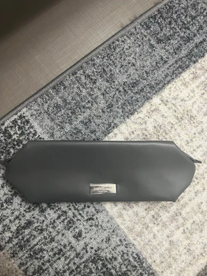 Grå necessär från Yves Saint Laurent - Snygg grå necessär från Yves Saint Laurent i ett stilrent och mjukt material. Väskan har en avlång, sexkantig form och en metallbricka med logga på framsidan. Perfekt för smink eller småprylar när du är på språng.