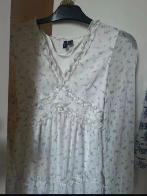 💙 Vero Moda luftig blommig klänning | XS | Vit & blå - Säljer en superfin långärmad klänning från Vero Moda i storlek XS. Klänningen har ett luftigt och skönt material med ett vackert blått blommönster som ger en romantisk och somrig känsla. Perfekt till både vardag, semester och festligare tillfällen.