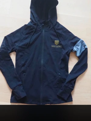 Svart hoodie från Maya Delorez - Snygg svart hoodie från Maya Delorez med dragkedj. Endast använd två gånger då jag slutade på ridning strl S nypris 999kr