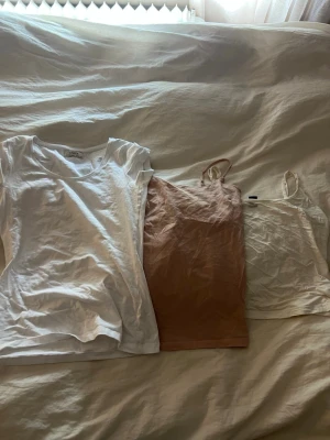 Tre toppar i vitt och rosa - Storlek Xs men olika former. 