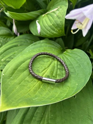 Brunt flätat läderarmband - Snyggt brunt armband i flätat läder med ett stilrent magnetlås i silverfärgad metall. Perfekt accessoar för dig som gillar en enkel men trendig look. Passar till de flesta outfits och är lätt att matcha med andra smycken. Har flera stycken så kontakta mig vid intresse☺️