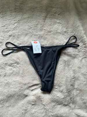 Svart bikiniunderdel - Svart bikiniunderdel helt oanvänd med lappar kvar. Storlek M 