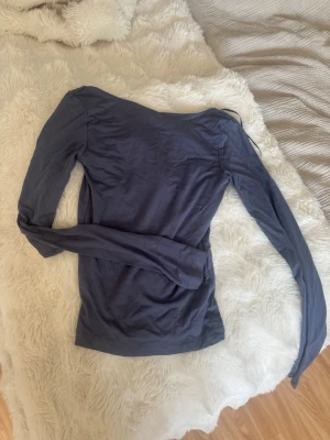 Mörkblå långärmad topp - Säljer en enkel och stilren mörkblå långärmad topp med rund halsringning. Toppen är i ett mjukt och stretchigt material som sitter snyggt på kroppen. Perfekt att matcha med jeans eller kjol för en clean look.