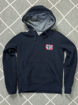 Geographical Norway mörkblå hoodie  - Väldigt snygg och trendig! Perfekt under sommaren. Storlek L men passar mer S. Mått: A:52 B:41 C:37 D:54 (cm)  ringen runt ena snöret har släppt, inget som påverkar looken! Skriv vid fundering😇✌️