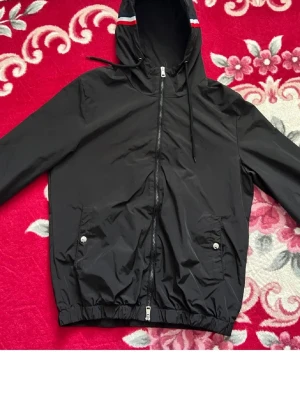 Svart vindjacka med huva - Svart Moncler vindjacka med storlek L passar även M är en skön jacka som är perfekt nu till hösten 