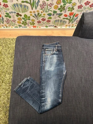 Lean Dean dry japanease selvedge - Snygga blå slim fit jeans med slitningar och tvättade detaljer på framsidan. Köptes i nudie butik men har inget og kvar. Den har några hål som måste lagas men man har livstids garanti och gratis reparation. Nypris 2500. Stl w29, l30