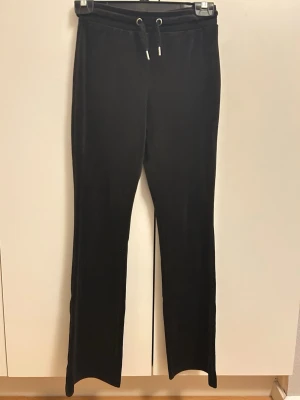 Svarta mjukisbyxor i velour - Säljer ett par svarta mjukisbyxor i mjuk velour med utsvängda ben. Byxorna har två fickor bak och en enkel, clean look som passar perfekt till chill dagar. Supersköna och stilrena! Passar perfekt ihop med min tidigare annons!!