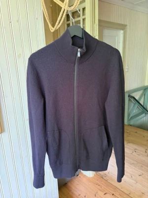 Mörklila ullkofta från Massimo Dutti - Snygg mörklila kofta i ull från Massimo Dutti med hel dragkedja framtill och två fickor. Hög krage och ribbade detaljer vid hals och ärmslut. Perfekt för lager-på-lager och en stilren look. Defekt syns på bild, passar S/M.  Hör av dig vid frågor// kan gå ner i pris vid snabb affär!😃/ Milton