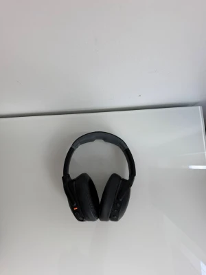 Svarta Skullcrushers EVO - Stilrena svarta trådlösa over-ear hörlurar med vadderade kåpor och justerbart huvudband. Hörlurarna har knappar på sidan för enkel styrning av musik och samtal. Modern design i plast och konstläder som ger både komfort och bra ljudupplevelse. 
