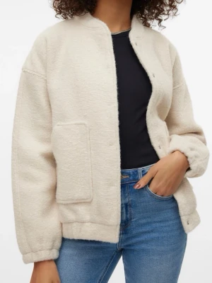Krämvit teddyjacka med ficka - Säljer en krämvit teddyjacka i mjukt, fluffigt material. Jackan har en stor fyrkantig ficka på ena sidan, tryckknappar framtill och avslappnad passform. Perfekt för dig som vill ha en mysig och trendig look.