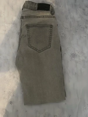 Grå jeans - Snygga grå jeans med slim passform. Klassisk femficksmodell och diskreta sömmar. Jeansen är tillverkade i ett mjukt denimtyg som ger en avslappnad look. Perfekta för dig som gillar stilrena och neutrala plagg.